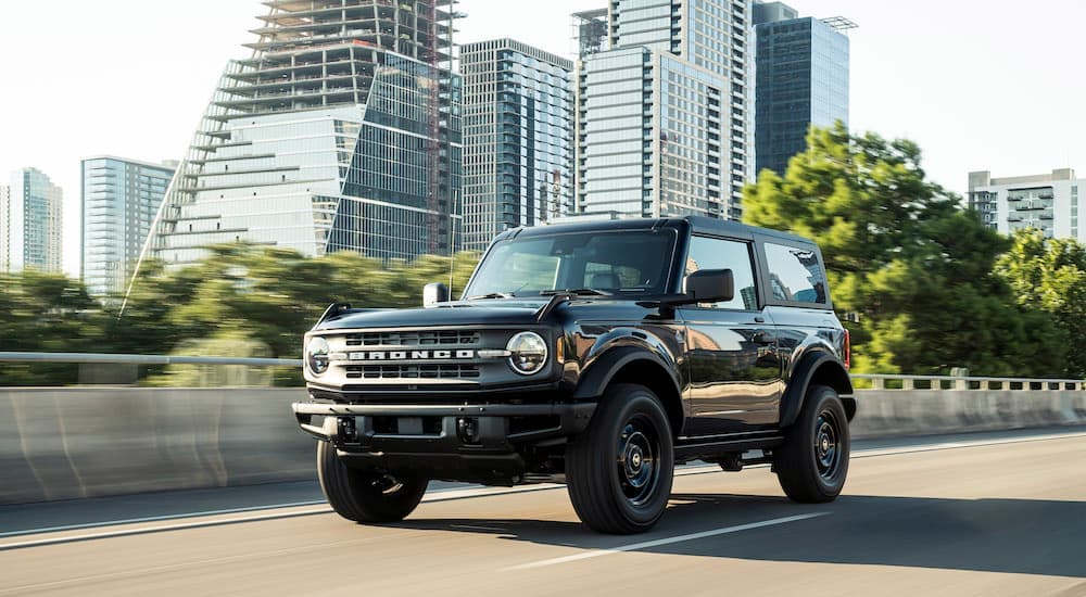 A black 2021 Ford Bronco Black Diamond driving through the city to a used Ford dealer.